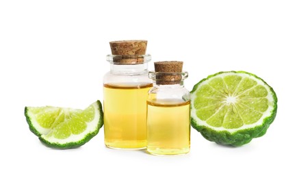 Bottles of essential oil and fresh bergamot fruit on white background
