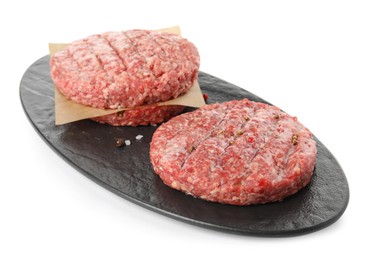 Raw hamburger patties with spices on white background