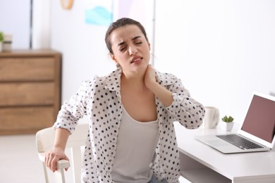 Woman suffering from neck pain in office. Bad posture problem