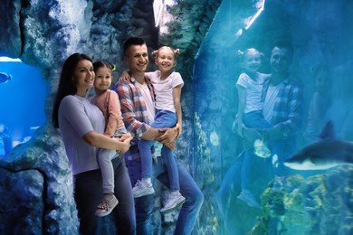 Happy family near aquarium in oceanarium. Spending time together