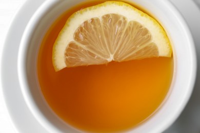 Cup with delicious immunity boosting tea and lemon, closeup