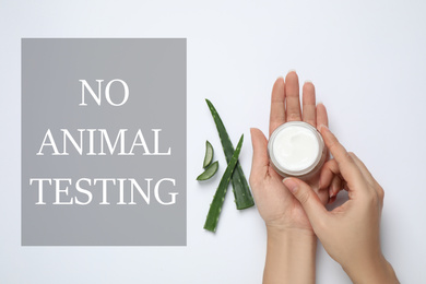 Woman with jar of cream, aloe and text NO ANIMAL TESTING on white background, flat lay