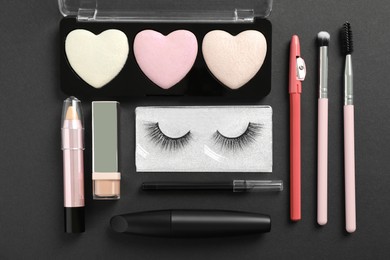 Photo of Set of makeup products on dark background, flat lay