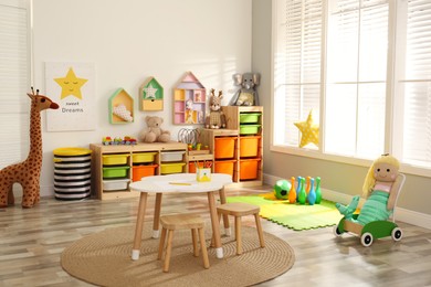 Stylish playroom interior with soft toys and modern furniture