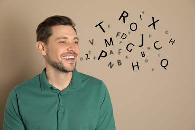 Smiling man and letters on beige background. Speech therapy concept