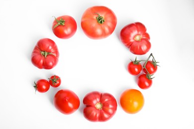 Frame of different ripe tomatoes on white background, flat lay. Space for text