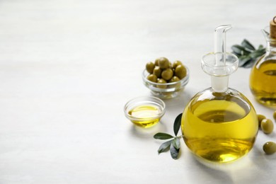 Bottle of fresh olive oil on white table, space for text