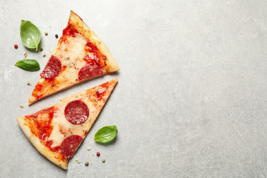 Slices of hot delicious pepperoni pizza on light grey table, flat lay. Space for text