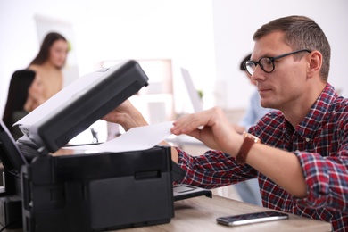 Employee using new modern printer in office