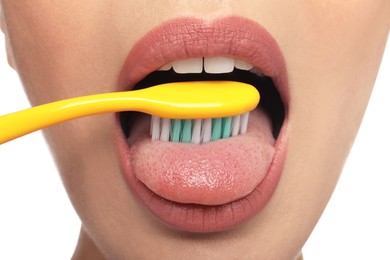 Woman brushing her tongue on white background, closeup. Dental care