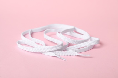 White shoe laces on light pink background