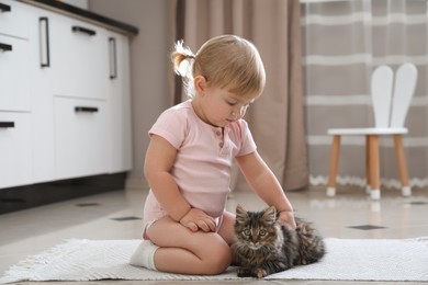 Photo of Cute little child with adorable pet on floor at home