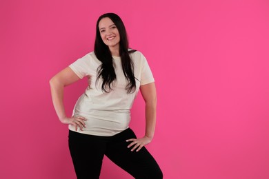 Beautiful overweight woman with charming smile on pink background. Space for text