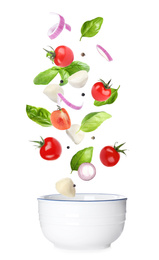 Mozzarella cheese, tomatoes, onion and basil leaves falling into bowl on white background