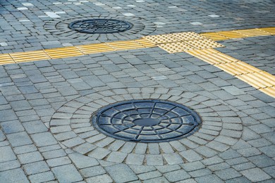 Metal sewer hatch on street tiles outdoors