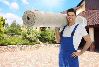 Worker with rolled carpet outdoors on sunny day