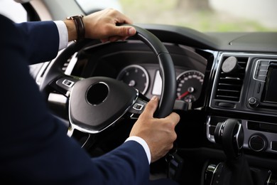 Man driving his car, closeup view of hands on steering wheel