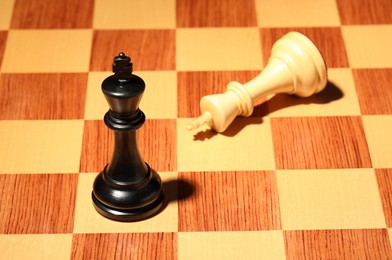 Wooden chessboard with game pieces, closeup view