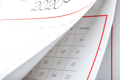 2020 paper calendar with turning pages as background, closeup