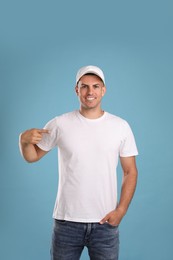 Happy man in white cap and tshirt on light blue background. Mockup for design