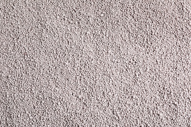 Textured chemical fertilizer for gardening as background, top view