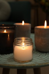 Photo of Lit candles on table in dark living room