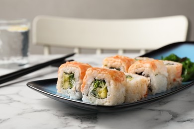 Delicious sushi rolls served on white marble table, closeup