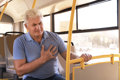 Senior man having heart attack in public transport