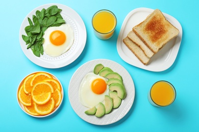 Flat lay composition with fried eggs on light blue background. Healthy breakfast