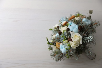 Beautiful wedding winter bouquet on white wooden table, top view. Space for text