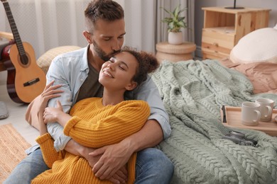Lovely couple enjoying time together on floor in bedroom