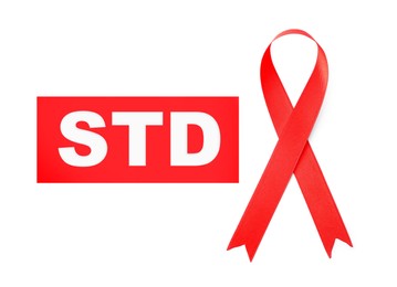 Red awareness ribbon and abbreviation STD on white background, top view 