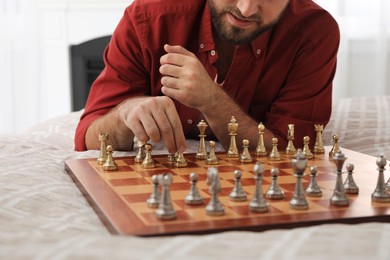 Man playing chess alone on bed at home, closeup