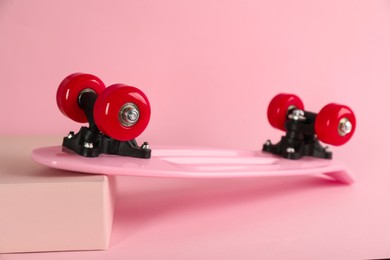 Pink skateboard on color background. Sport equipment