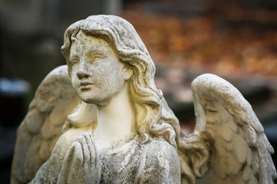 Photo of Beautiful statue of angel at cemetery, closeup. Religious symbol