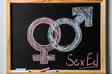 Gender symbols and text "SEX ED" written on small blackboard