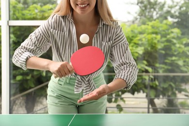 Woman playing ping pong indoors, closeup view