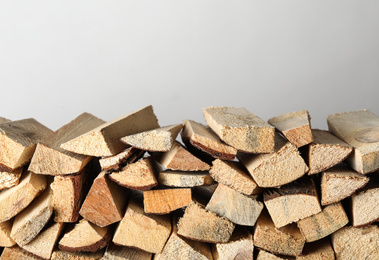 Cut firewood on light grey background. Heating in winter
