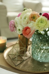 Beautiful ranunculus flowers in vase on wooden table indoors, closeup