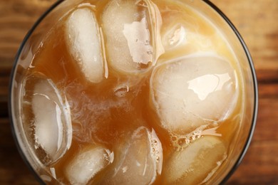 Coffee with milk and ice cubes in glass, top view