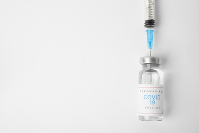 Filling syringe with coronavirus vaccine on white  background, flat lay. Space for text