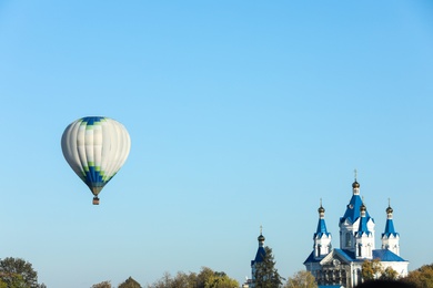 KAMIANETS-PODILSKYI, UKRAINE - OCTOBER 06, 2018: Beautiful view of hot air balloon flying near Saint George's Cathedral. Space for text