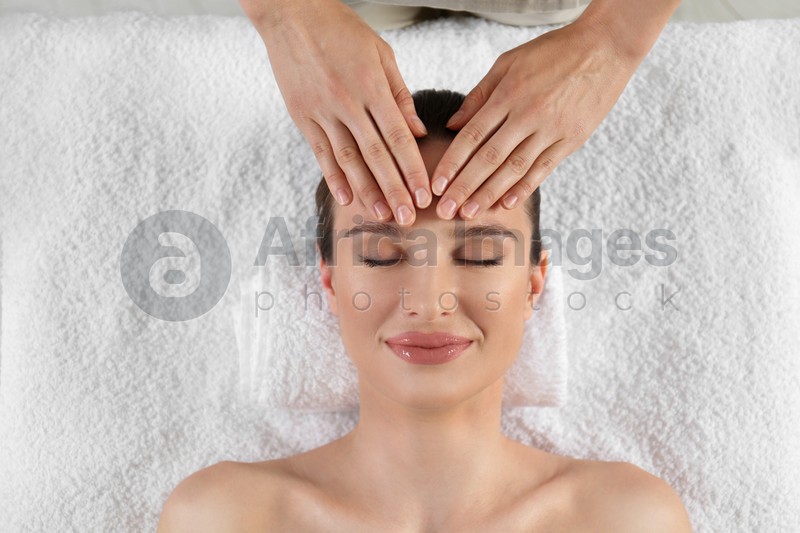 Photo of Beautiful young woman enjoying massage in spa salon, top view