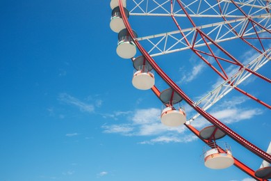 Beautiful large Ferris wheel against blue sky, low angle view
