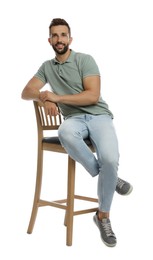 Handsome man sitting on stool against white background