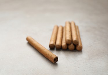 Many expensive cigars on light grey table