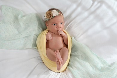 Photo of Adorable newborn baby on bed, top view
