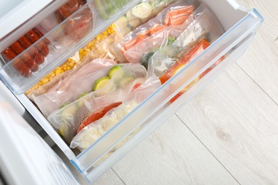 Photo of Vacuum bags with different products in fridge, above view. Food storage