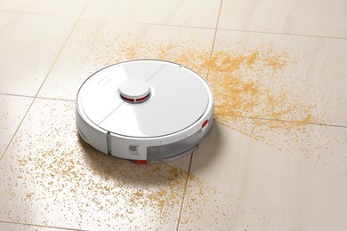 Photo of Robot vacuum cleaner removing dirt from floor in room