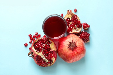 Glass of pomegranate juice and fresh fruits on color background, top view
